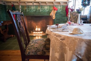 Dining room breakfast setting by fireplace with holiday decor