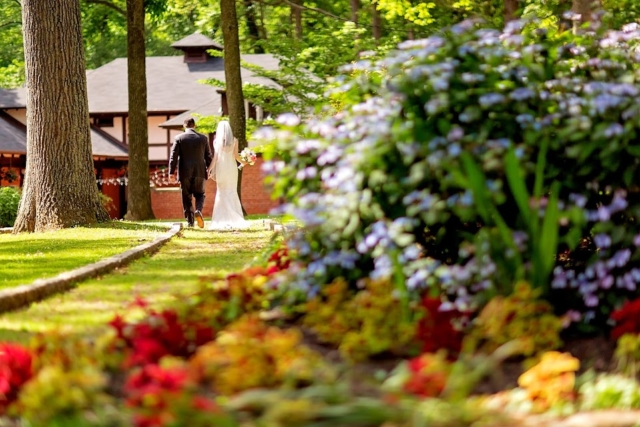 Colorful flowers in the gardens and the bride and groom are walking off in the distance.