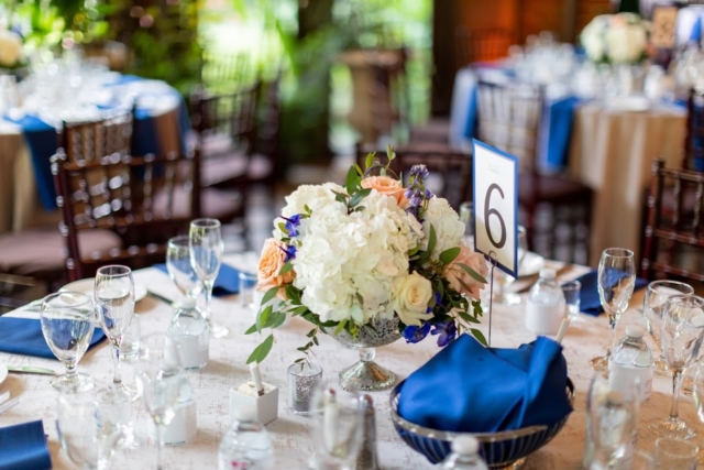 White, peach and blue florals on a table with white and blue linens.