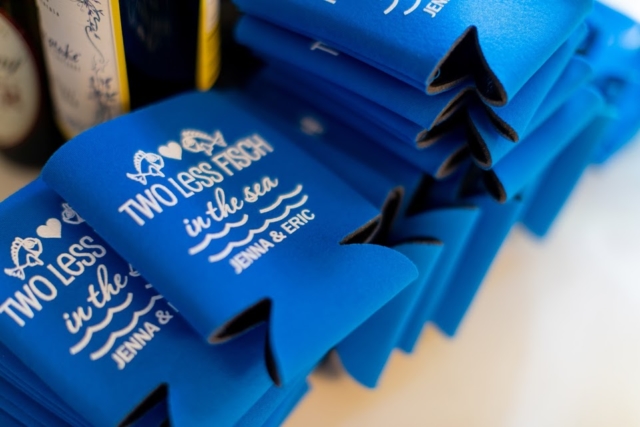 Blue drink koozie with white lettering.