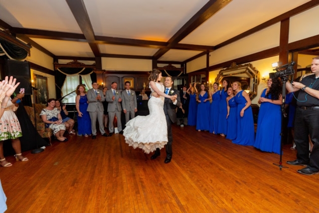 Groom holding bride up as they dance.