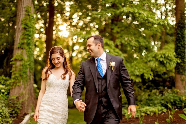 Couple walking in the gardens holding hands at sunset.