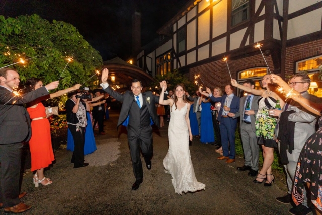 Couple walking past friends for a sparkler exit.